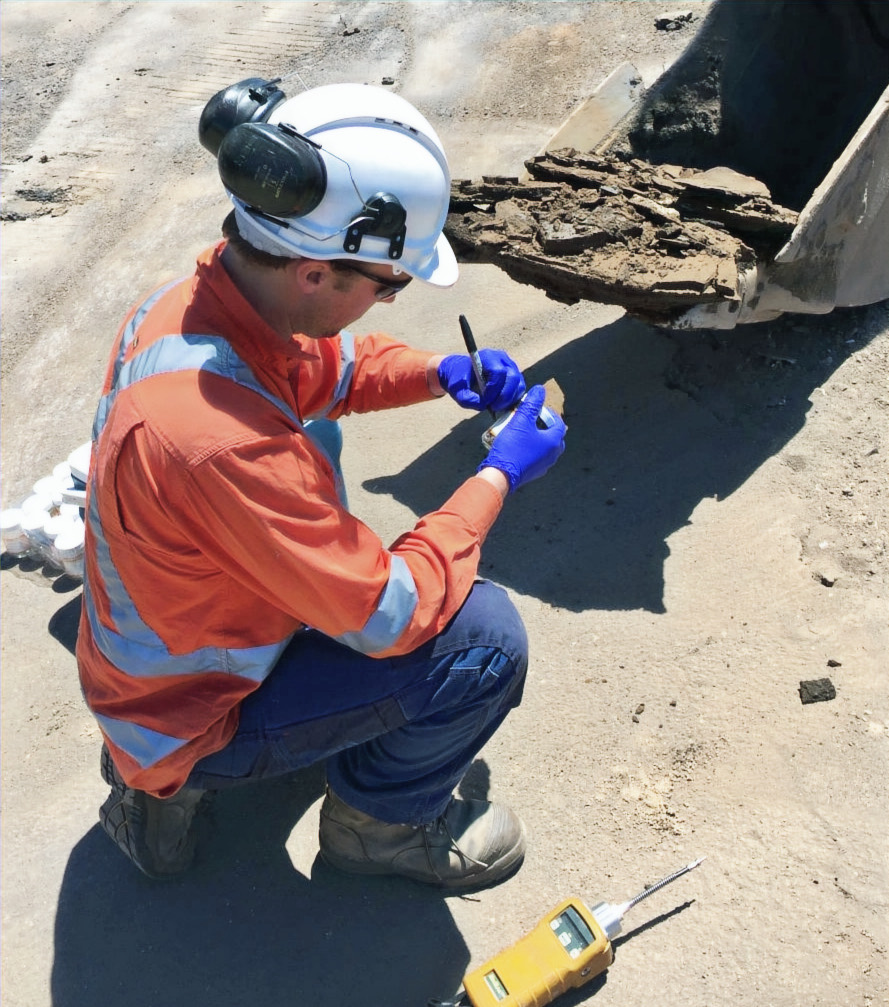 An environmental scientist logging a soil sample on site